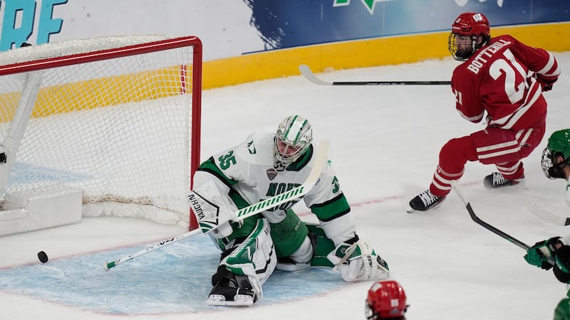 Wisconsin forward Ryan Botterill (21) scores against North Dakota goaltender Jan Spunar (35)...
