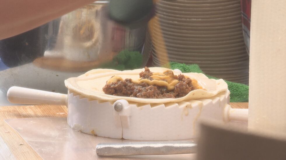 Maria Carlo, owner of Boriken Mart, creates an empanada while at the Rothschild Farmers Market.