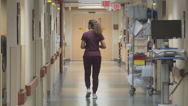 A nurse walking down a hospital hallway.