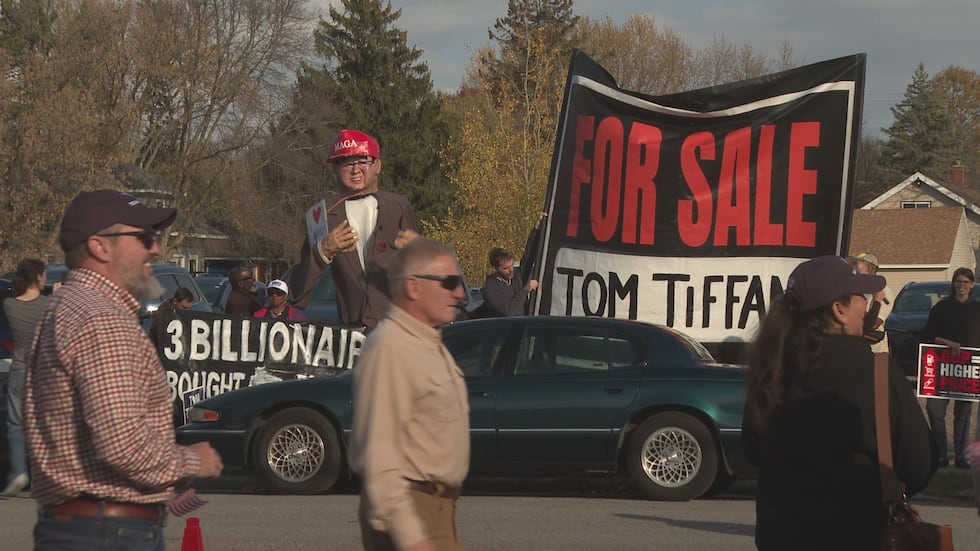 Protestors line the road across the street from a Tom Tiffany rally