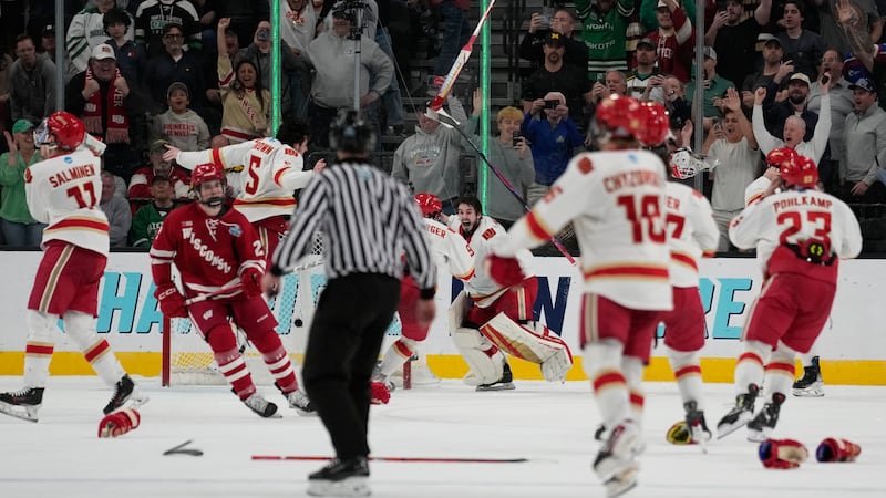 Denver players celebrate after defeating Wisconsin in the championship game at the NCAA Frozen...